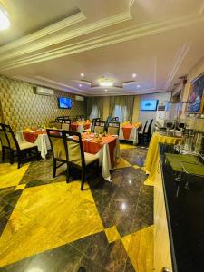 a restaurant with tables and chairs in a room at Qualibest Grand Hotels in Abuja