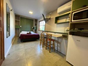 a room with a kitchen and a bedroom with a bed at Moçamba LODGE Contêiner in Florianópolis +23 photos