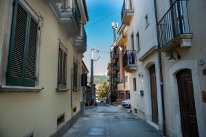 a narrow alley with buildings and a car on a street at Casa Fedele in LʼAquila