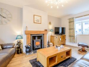 a living room with a couch and a fireplace at 3 Bed in Kielder 78280 in Falstone