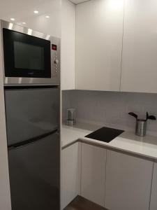 a kitchen with a refrigerator and a microwave at Puerta de Hierro Apartments in Madrid