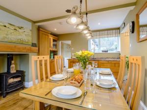 a dining room with a table with plates and glasses at 3 Bed in Kielder 78280 in Falstone