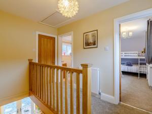 a room with a staircase and a chandelier at 3 Bed in Kielder 78280 in Falstone