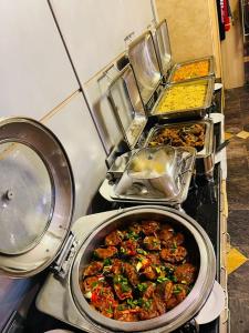 a bunch of food in a pot on a stove at Qualibest Grand Hotels in Abuja