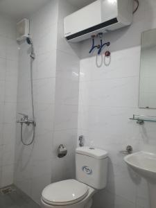 Baño blanco con aseo y lavamanos en Bach Dang Apartment Hai Duong, en Hải Dương