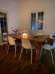 a dining room table with white chairs around it at Villa Vlamari in Vathý +24 photos