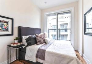 a bedroom with a large bed with a window at Luxe Toronto Townhome, Rooftop Terrace, Parking in Toronto