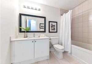 a white bathroom with a toilet and a sink at Luxe Toronto Townhome, Rooftop Terrace, Parking in Toronto +19 photos