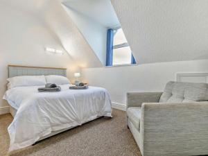a bedroom with a bed and a couch and a window at 2 Bed in Woolacombe 76350 in Woolacombe