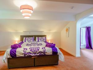 1 dormitorio con 1 cama grande con sábanas moradas y blancas en 2 Bed in Kirkby Stephen 78605 en Kirkby Stephen