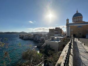 a view of a town with a church and water at Fouli,Syros Apartment,Ermoupoli in Ermoupoli
