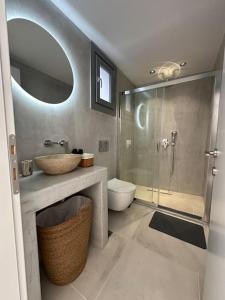 a bathroom with a sink and a shower and a toilet at Fouli,Syros Apartment,Ermoupoli in Ermoupoli