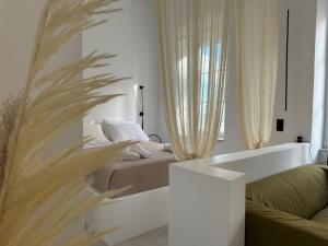a white living room with a bed and a couch at Fouli,Syros Apartment,Ermoupoli in Ermoupoli
