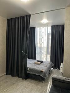a bedroom with a bed and a large window at Arcadia Adelina in Odesa