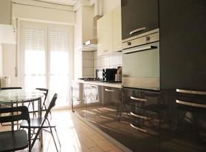 Corsico Comfort Home في كورسيكو: مطبخ مع طاولة وغرفة طعام