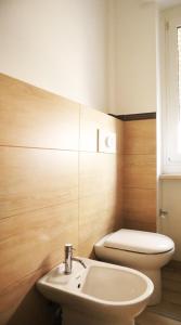 Corsico Comfort Home في كورسيكو: حمام مع حوض أبيض ومرحاض