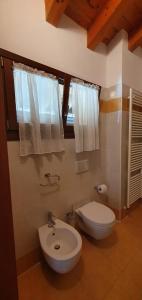La salle de bains est pourvue de toilettes blanches et d'un lavabo. dans l'établissement Jesolo Living at Golf Club Jesolo, à Jesolo