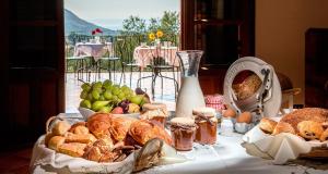 uma mesa coberta com cestas de pão e pastelaria em Poggio di mare em Castelluzzo