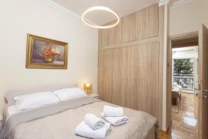 a bedroom with a bed with two towels on it at King George 32 Luxury Apartment in Thessaloniki