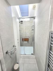 baño con ducha y puerta de cristal en Sensational Room Stays- Callcott Road, en Londres