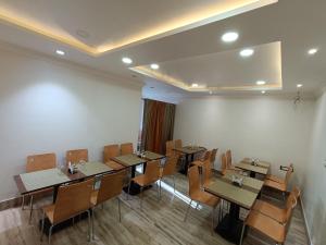 una sala da pranzo con tavoli e sedie in legno di Swet Palash Resort a Purulia