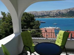 a balcony with two chairs and a view of the water at Apartments Andrea in Baška