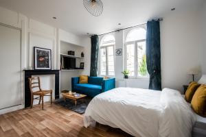 um quarto com uma cama e uma cadeira azul em Appartement Lumineux et cozy à LILLE Lomme em Lille