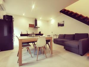 eine Küche und ein Wohnzimmer mit einem Tisch und einem Sofa in der Unterkunft Le quai du Rhône in Sainte-Colombe