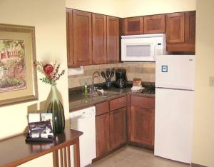 a kitchen with wooden cabinets and a white refrigerator at Staybridge Suites Harrisburg-Hershey, an IHG Hotel in Harrisburg