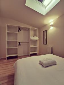 um quarto com uma cama branca e uma clarabóia em Le quai du Rhône em Sainte-Colombe