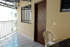 una puerta de madera con una silla en el balcón en Hotel Cancioneiro, en Sinop