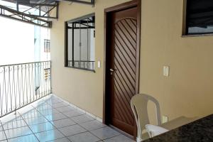 a wooden door with a chair on a balcony at Hotel Cancioneiro in Sinop