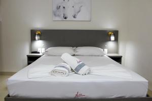 1 cama blanca grande con 2 toallas en Hotel Cancioneiro, en Sinop