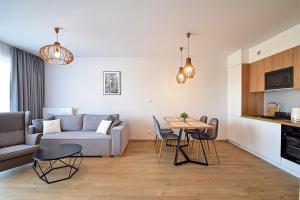 a living room with a couch and a table at Przystań Apartamenty Sarbinowo in Sarbinowo