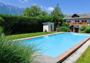a swimming pool in the yard of a house at Hotel Villnerhof in Egna