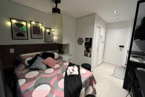 1 dormitorio con 1 cama con edredón rosa y negro en Espaço único ao lado do teatro Renault e hospitais, en São Paulo