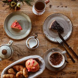 een houten tafel met borden eten en kopjes koffie bij Hôtel de la Loze in Courchevel