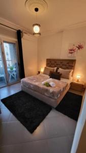 una camera da letto con un grande letto con due tappeti di Appart Hotel Tanger Paname a Tangeri