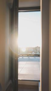 uma janela num quarto com o sol a brilhar em K&T Estate Resort & Spa - Flughafennahe Gästesuite em Hofheim
