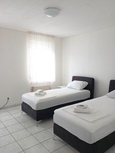 two beds sitting in a room with a window at Monteurwohnung Renate in Saarbrücken