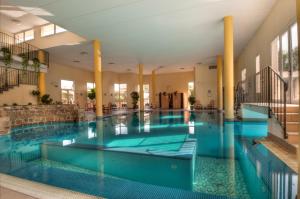 una grande piscina con acqua blu in un edificio di Hotel Terme Belsoggiorno ad Abano Terme Altre 46 foto