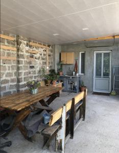 a patio with a wooden table and a kitchen at Julia's Place - Apartment, Garden & BBQ in Vagharshapat
