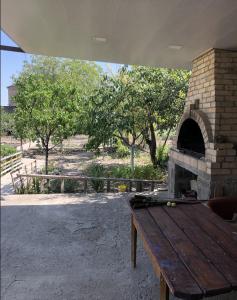 a picnic table with a brick oven in a yard at Julia's Place - Apartment, Garden & BBQ in Vagharshapat