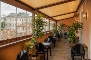 un restaurante con mesas, sillas y ventanas en Stendhal Luxury Suites, en Roma