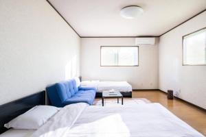 a room with two beds and a blue couch at Snow Fever - Clique in Hakuba