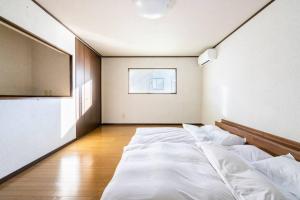 a large white room with a large bed in it at Snow Fever - Clique in Hakuba