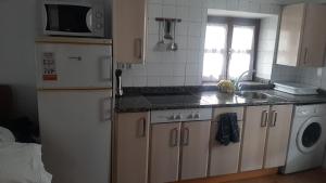 a kitchen with a sink and a stove and a refrigerator at Pequeño apartament rural con un gran jardin. WIFI in Ispáster