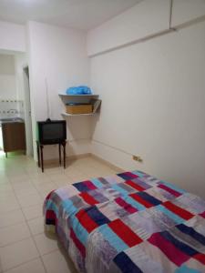 um quarto com uma cama e uma cadeira em Estudio en el Centro de Asunción em Assunção