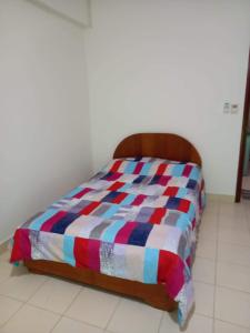 a bed with a colorful comforter in a room at Estudio en el Centro de Asunción in Asuncion