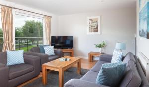 a living room with two couches and a coffee table at KingFisher Hot Tub & log Burner house on Premium lakeside with Resort Facilities in Saint Columb Major
